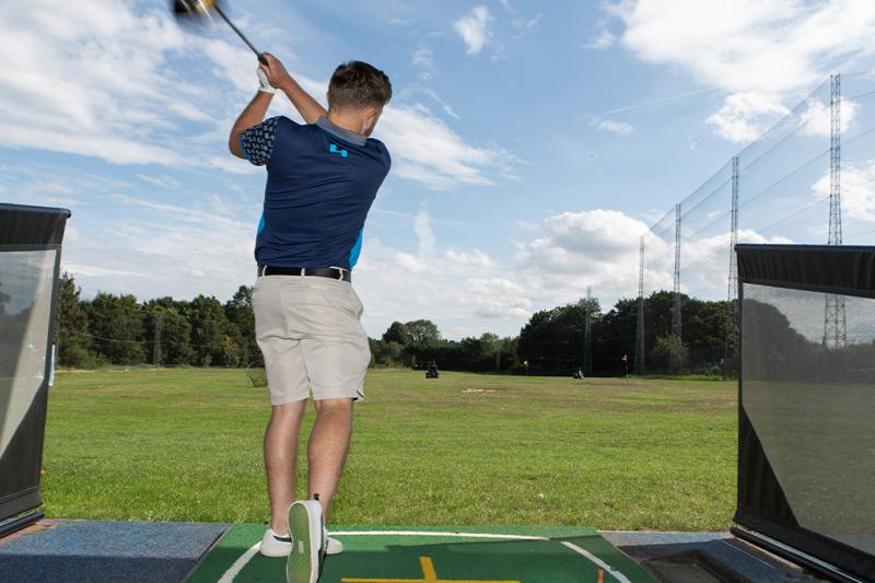 Man hitting a shot on a driving range