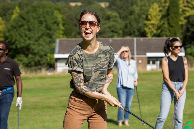 Friends playing golf together smiling on a golf course