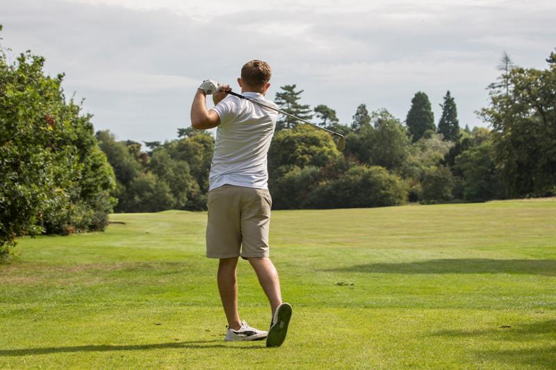 Man hitting a tee shot on a golf course