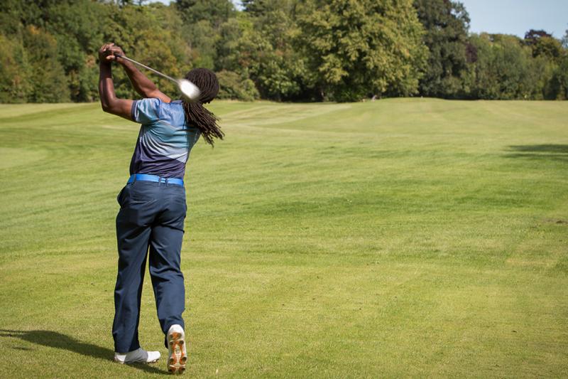 Man using a driver on a golf course