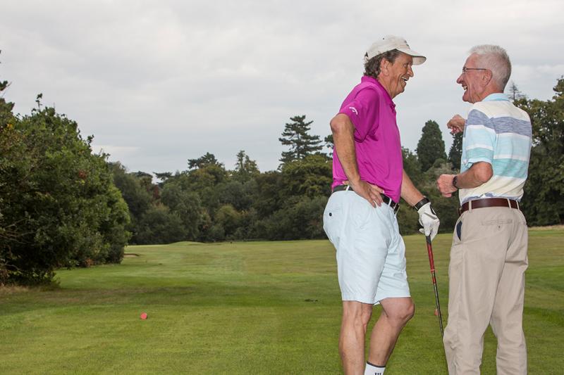 Men talking by the tee on a golf course