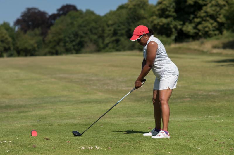 A lady taking a tee shot on the golf course