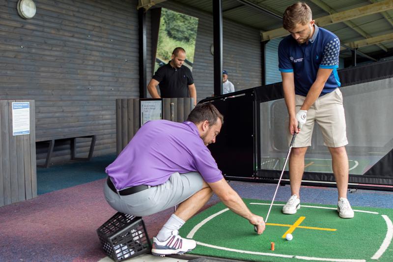 Man getting a golf lesson on the driving range