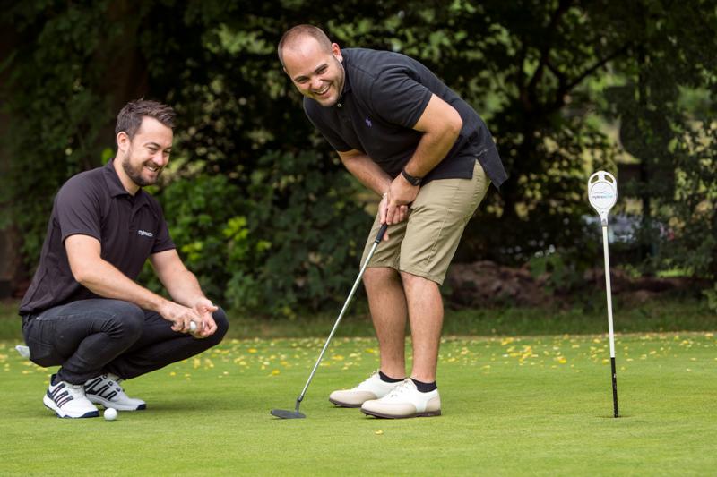 Man receiving a golf putting lesson