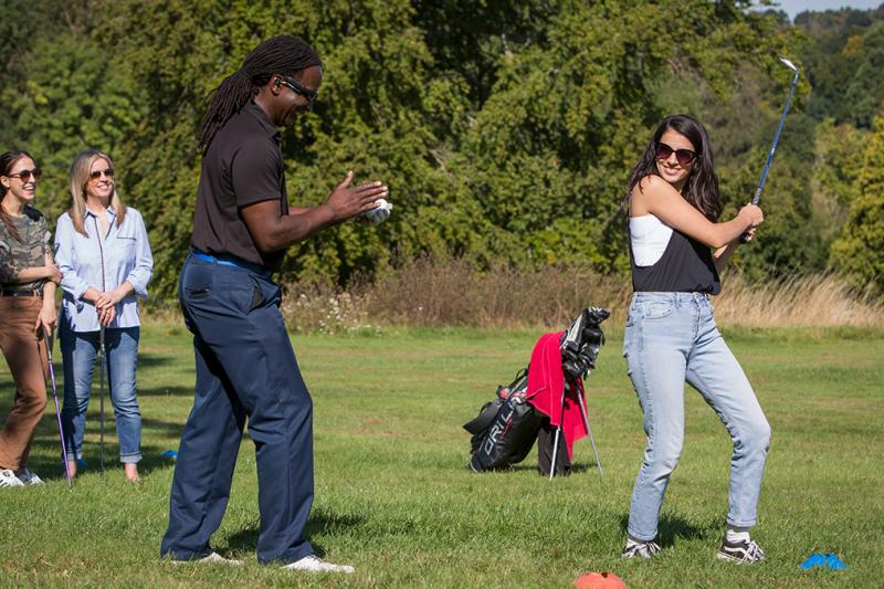 A golf lesson where a lady has just hit a good shot