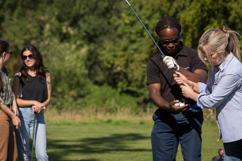 A group golf lesson with a Golf Pro talking to a lady