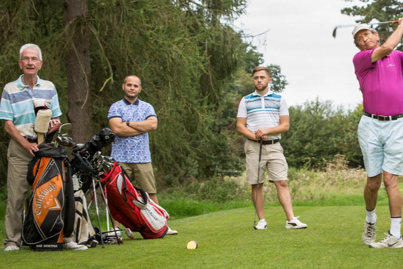 Group of golfers teeing off