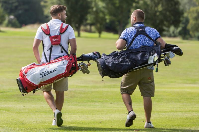 Two golfers walking along the fairway