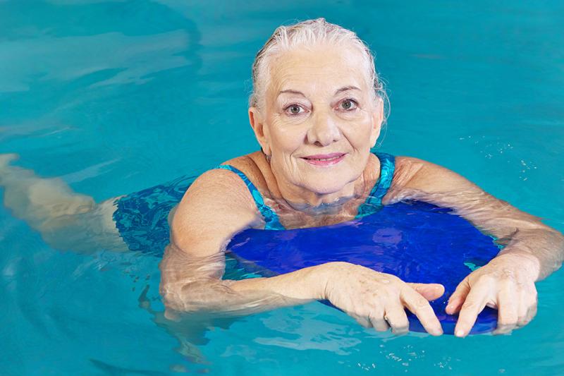 Adult Lady swimming in a pool with a float