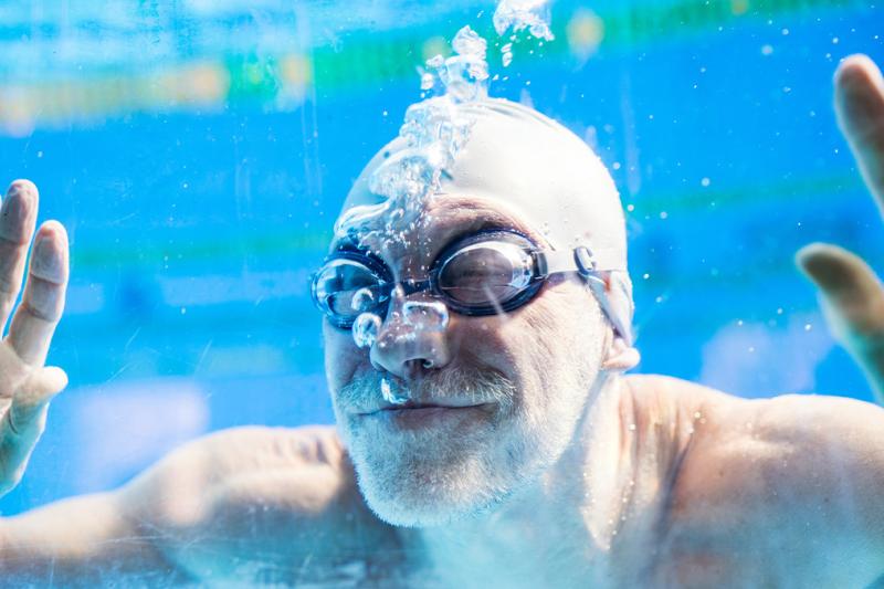 Man underwater blowing bubble at the swimming pool