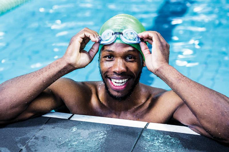 Adult man swimming with hat at the swimming pool