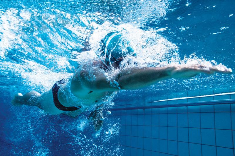 Man swimming underwater at a swimming pool