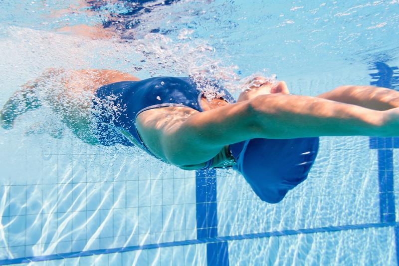 Adult lady diving underwater in a swimming pool