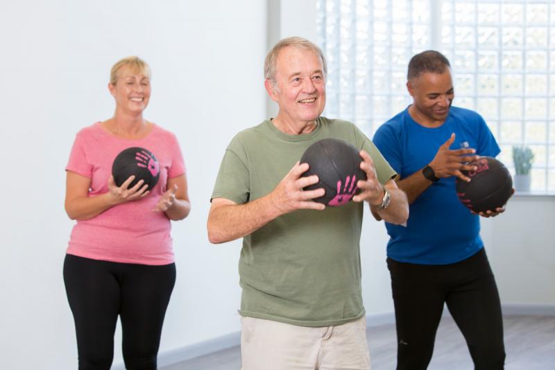 Group of people exercising with weighted balls